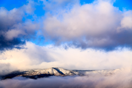 Cloud-shrouded mountain peak atop Arizona's Mogollan Rim during a winter storm.