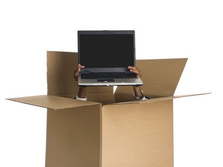 Hands delivering a laptop from a cardboard box.