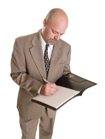 Stock photo of a well dressed businessman taking notes in a notebook, isolated on a white background.の写真素材