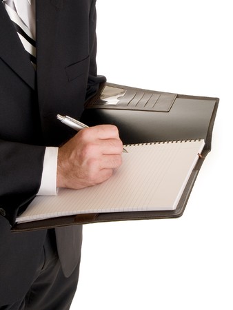 Stock photo of a well dressed businessman taking notes in a notebook.の写真素材