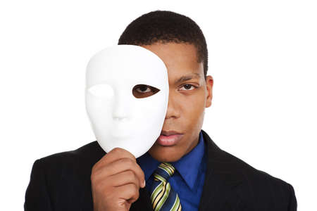Isolated studio shot of a businessman holding a blank costume mask up to his face and looking at the camera.の写真素材