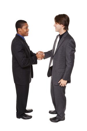 Isolated studio shot of two businessmen shaking hands in a warm, friendly greeting.の写真素材