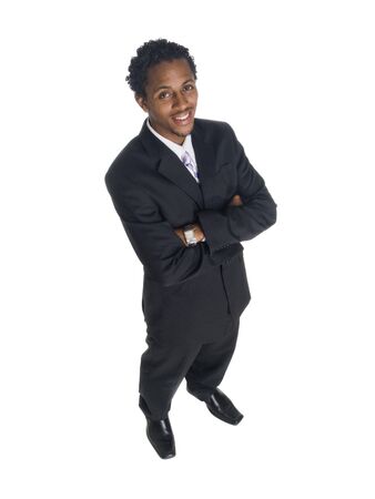 Isolated high angle studio shot of a businessman smiling at the camera with arms crossed.の写真素材