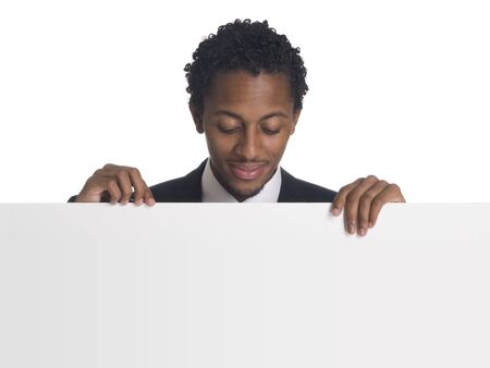 A well dressed businessman holds a blank sign ready for your message.の写真素材