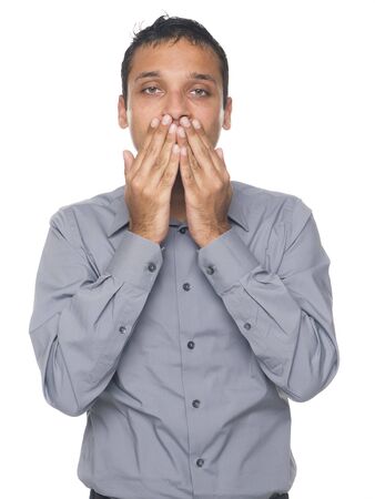 Isolated studio shot of a businessman in the Speak No Evil pose.の写真素材