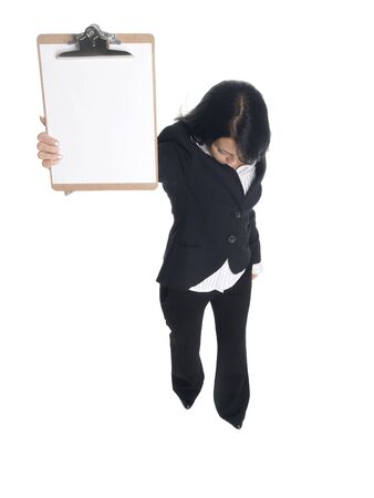 Isolated studio shot of a businesswoman presenting a blank clipboard while looking down.の写真素材
