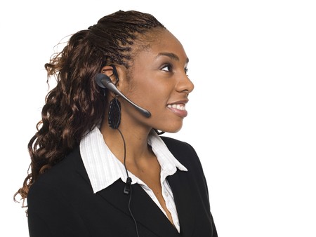 Isolated studio shot of a smiling businesswoman talking on a customer service telephone headset.の写真素材