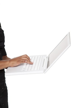 Isolated close up studio shot of a Latina businesswoman typing on a latptop keyboard she is holding in her hand.の写真素材
