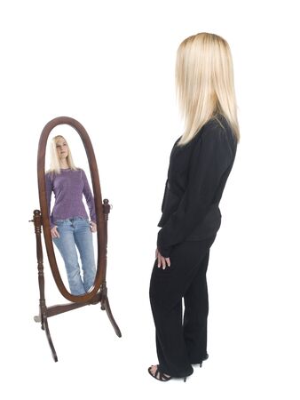 Isolated full length studio shot of a businesswoman looking into a mirror and wishing she had the day off.の写真素材