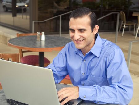 Handsome hispanic businessman surfing the internet on a laptop.の写真素材