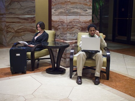 Hotel guests waiting in an upscale hotel lobby.の写真素材