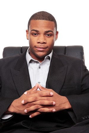 Isolated studio shot of an African American businessman rexlaxing in a nice office chair.の写真素材