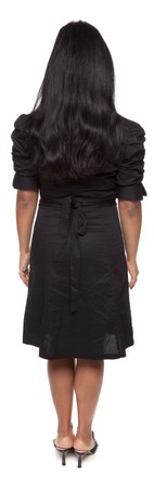 Isolated full length studio shot of a Latina businesswoman facing away from the camera with arms at her sides.の写真素材