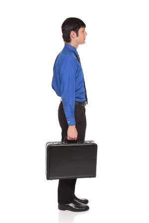 Isolated studio shot of a Caucasian businessman carrying a briefcase.の写真素材