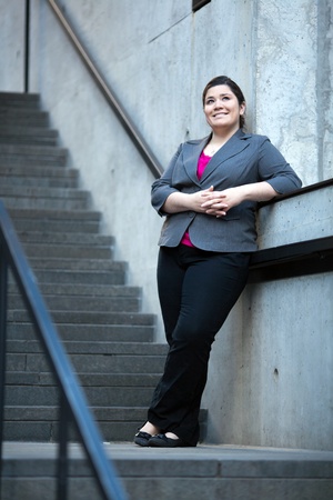 Stock photo of a well dressed businesswoman taking a break and leaning on the railing of a staircase.の写真素材