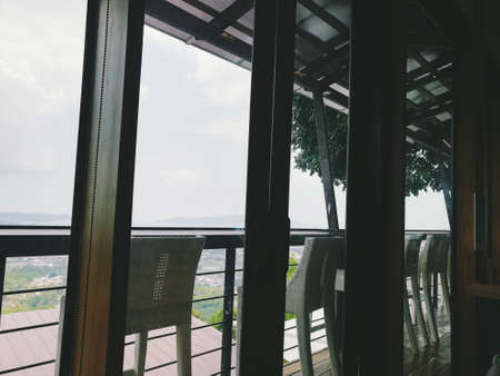 Chairs are arranged outside the window, which is a place for watching the sky.の写真素材