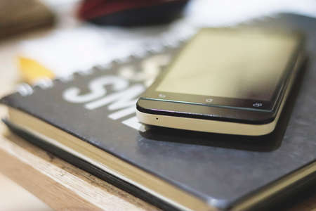 Choosing focus on microphone of  smartphone placed on a black notebook.の写真素材