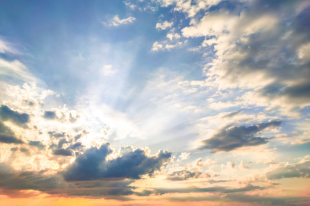 Beautiful dramatic sky opens with rain clouds and soft sunlight reveals blue gradient of atmosphere. Background photos of nature before sunset in autumn give feeling of calm, freedom, and hope again.の写真素材