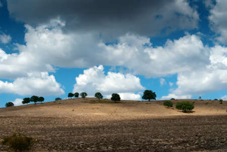 landscape with broken ground and sunny sky with white cloudsの写真素材