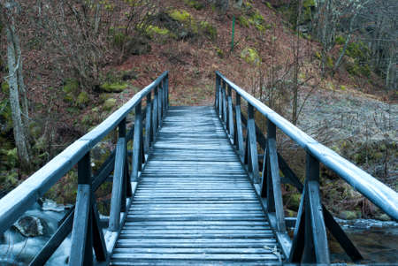 Wooden bridge over the river in the winter