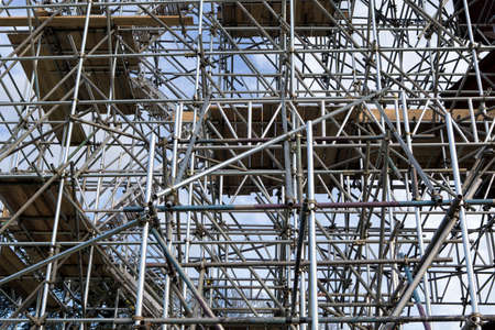 Metal scaffold and woden platforms on construction site の写真素材