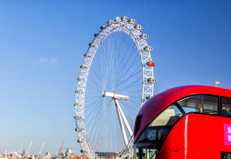 LONDON, UK - JANUARY 2, 2015: The London Eye and iconic red bus. London Eye (135 m tall, diameter of 120 m), a famous tourist attraction over river Thamesのeditorial素材