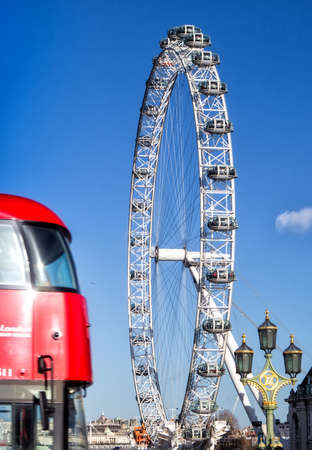 LONDON, UK - JANUARY 2, 2015: The London Eye and iconic red bus. London Eye (135 m tall, diameter of 120 m), a famous tourist attraction over river Thames.のeditorial素材