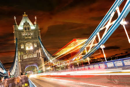 Tower Bridge in London, UK at night with moving red double-decker bus leaving light tracesのeditorial素材