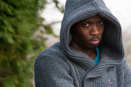 Young man with his hood up looking angrily at the cameraの写真素材