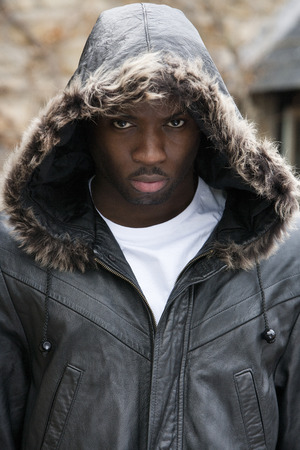Young man with his hood up looking angrily at the cameraの写真素材