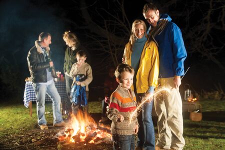 Family in garden enjoying a bonfire and playing with sparklersの写真素材