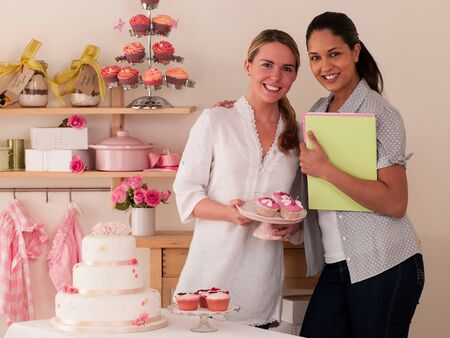 Two women making cakes for their bakery in a houseの写真素材