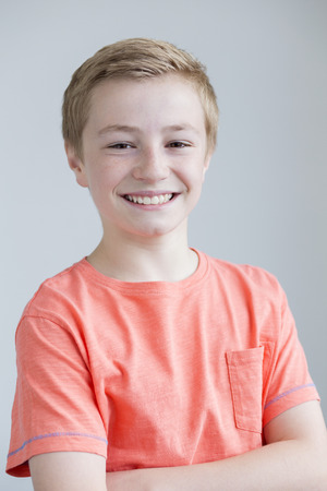 Portrait of a young boy on a plain background with his arms foldedの写真素材