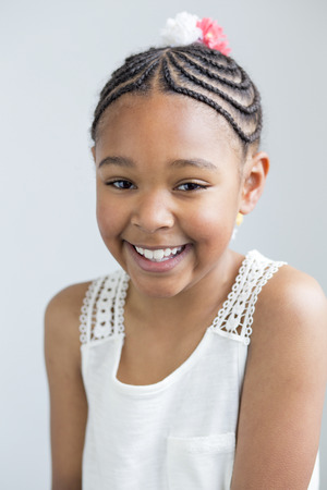 Portrait of a pretty, young, mixed race girl on a white background.の写真素材