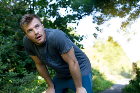 Young man having a quick break from his runの写真素材
