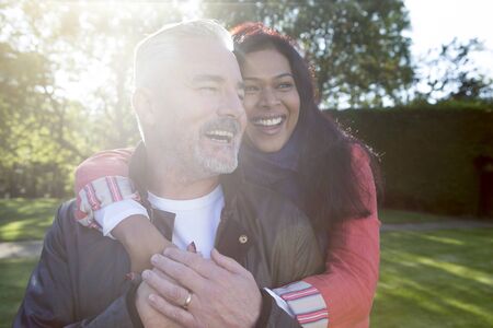 Happy couple posing in the sunshine outdoorsの写真素材