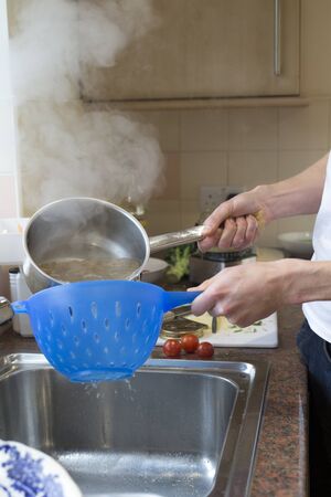 Spaghetti being sieved after being boiled in water.の写真素材