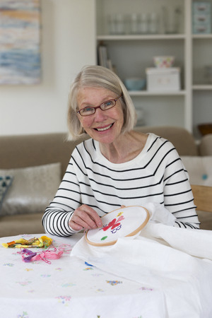 Senior woman doing broidery at homeの写真素材