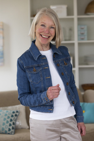 Portrait of a senior woman in her home.She is wearing a denim jacket.の写真素材