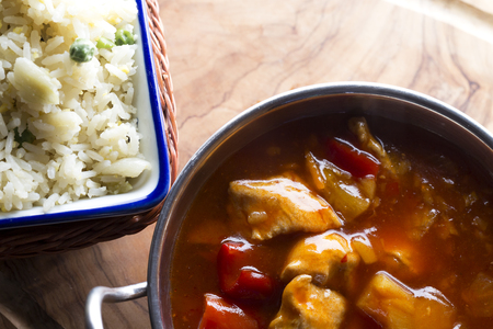 View from above of a dish with curry in it and a portion of riceの写真素材