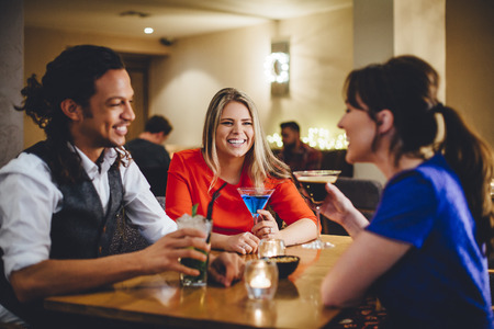 Group of friends enjoying cocktails in a restaurant.の写真素材