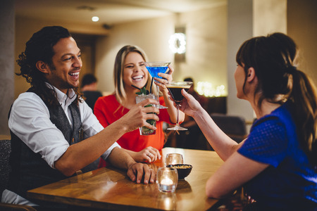 Group of friends toasting cocktails in a restaurant.の写真素材