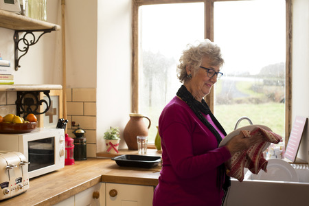 Shot of Grandma drying dishes in the kitchenの写真素材