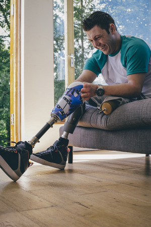 quadriplegic amputee putting his artificial legs on at home.の写真素材