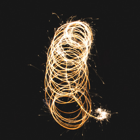 Squiggle shape made with a sparkler in a garden, using long exposure. の写真素材