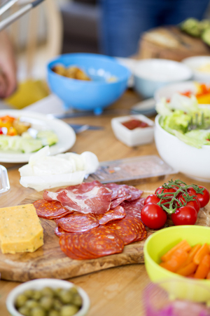 Mediterranean style food on a table including cured hams, cheeses, tomatoes and salad. の写真素材