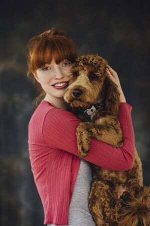 Woman posing with her pet dog in her arms.の写真素材