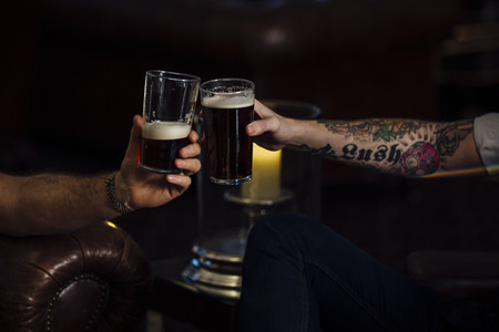 Close up shot of two men toasting their pints.の写真素材