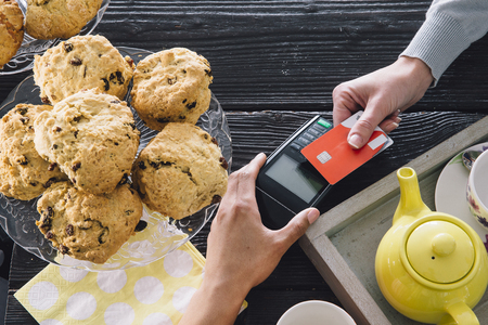 A contactless card payment is being made in a cafe. 