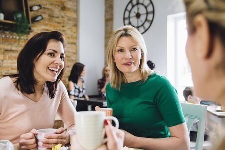 Point of view shot of women socialising over coffee in a cafe.の写真素材